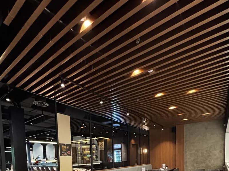 Slatted timber ceiling with warm downlights at GOSANCHON